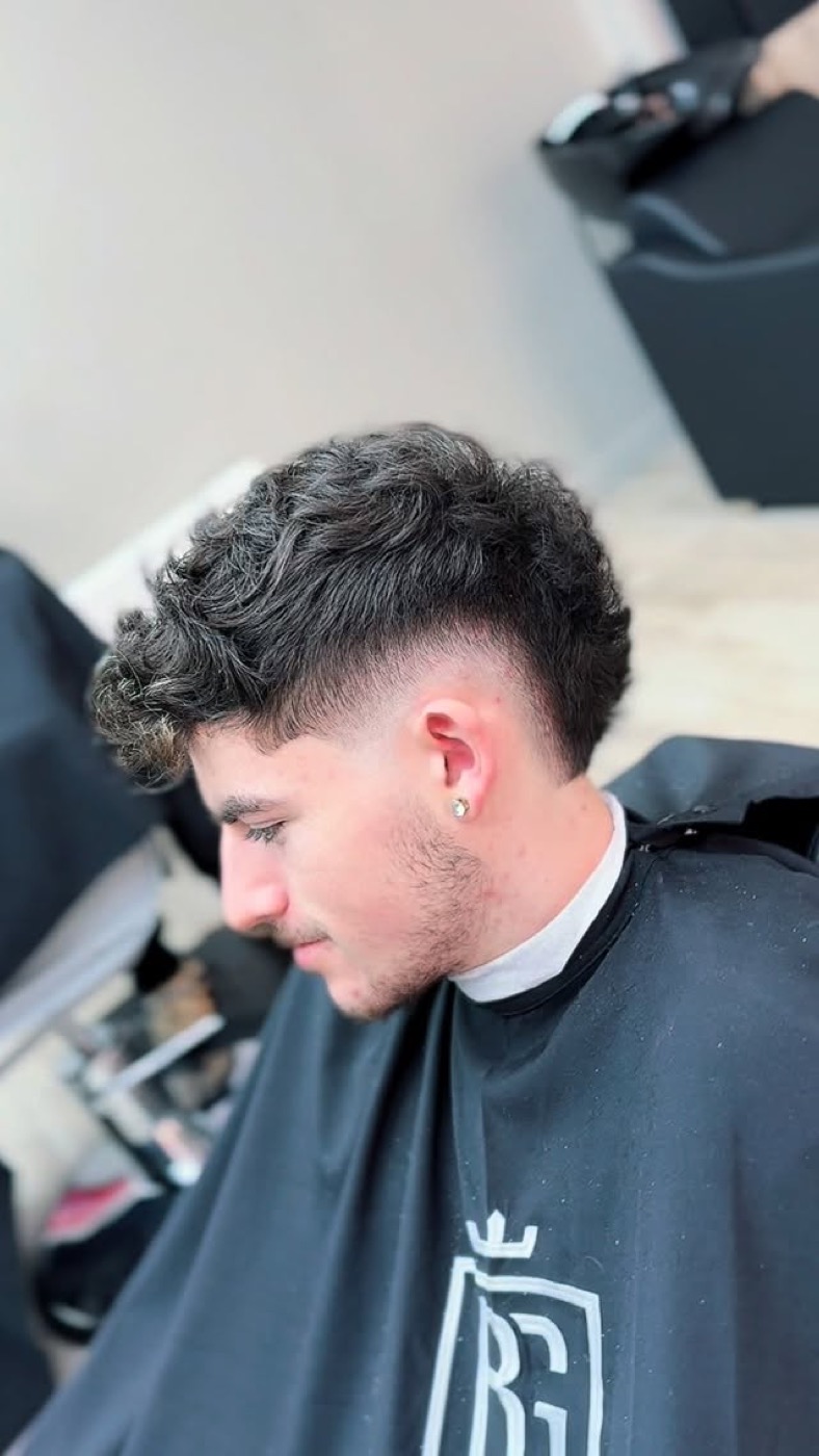Coupe sur cheveux bouclés avec boucles texturées sur le dessus et dégradé net, réalisée chez BG Barbershop à Beynes