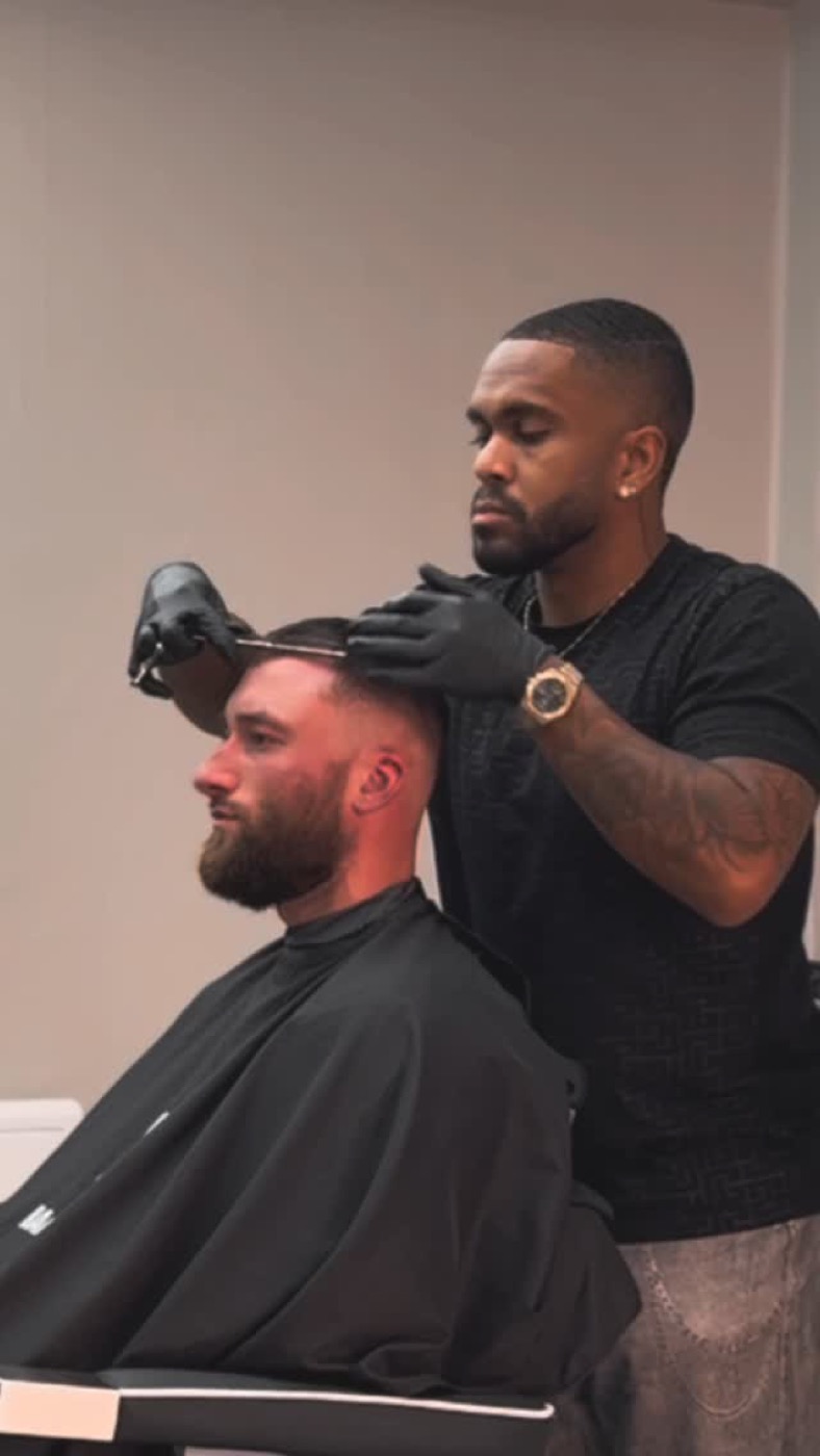 Barbier de BG Barbershop à Beynes travaillant aux ciseaux le dessus d'un client, cheveux propres au fini mat